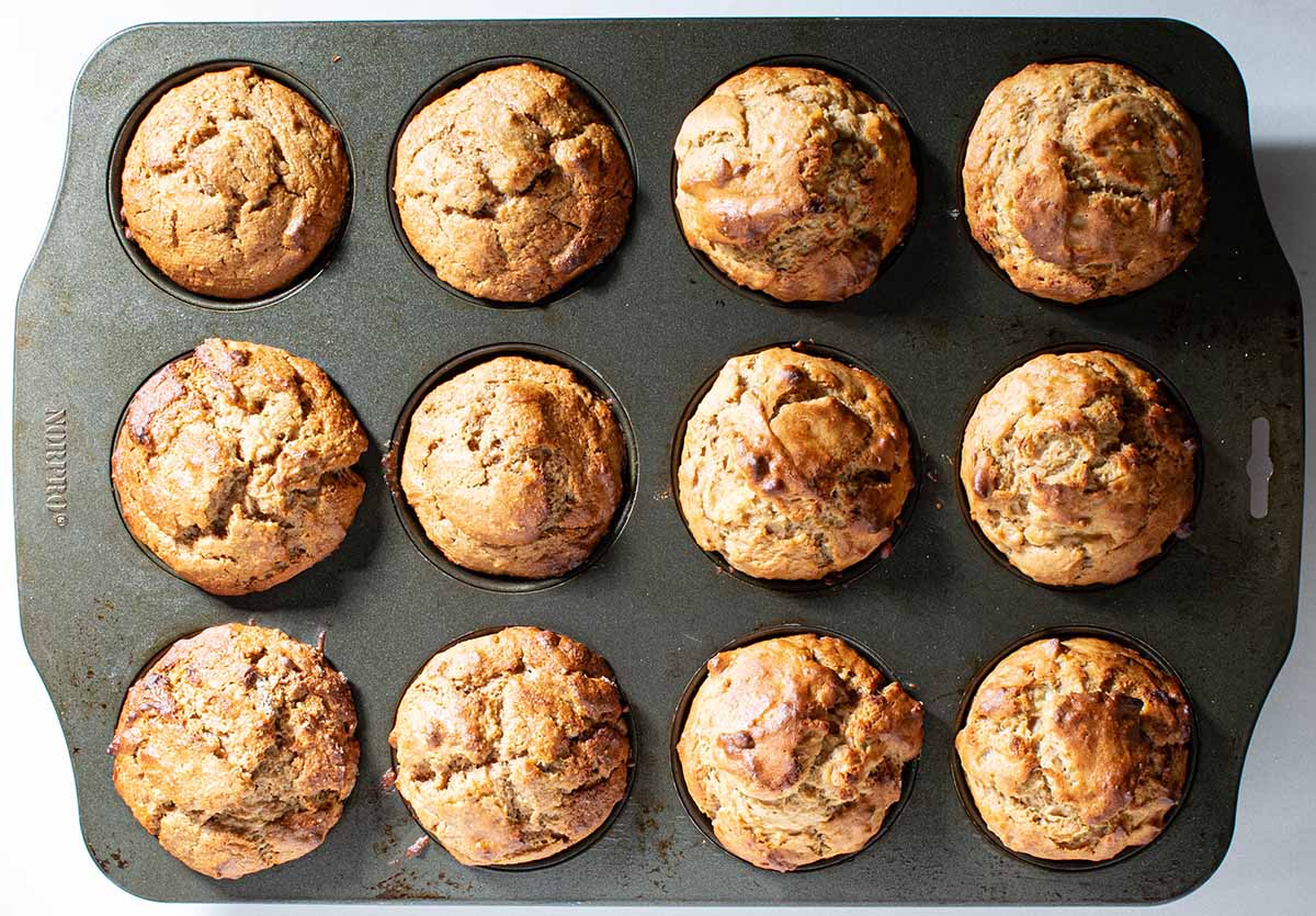 The same muffin tin after the peanut butter banana muffins finished baking. The tops are slightly domed and golden brown.
