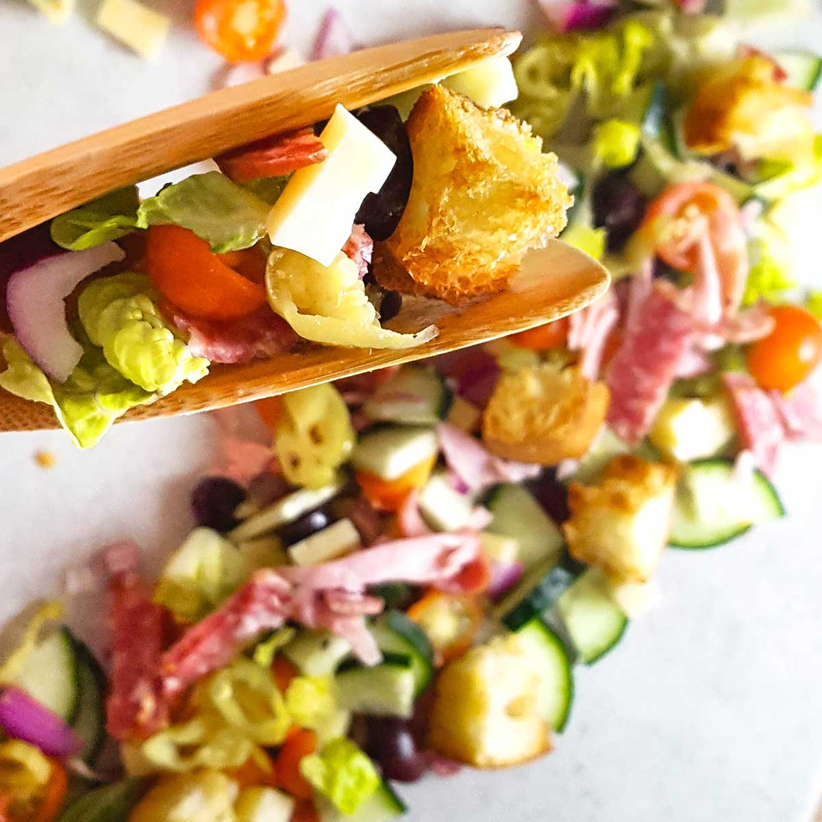 Italian sub salad with closeup of croutons, cheese, and salami