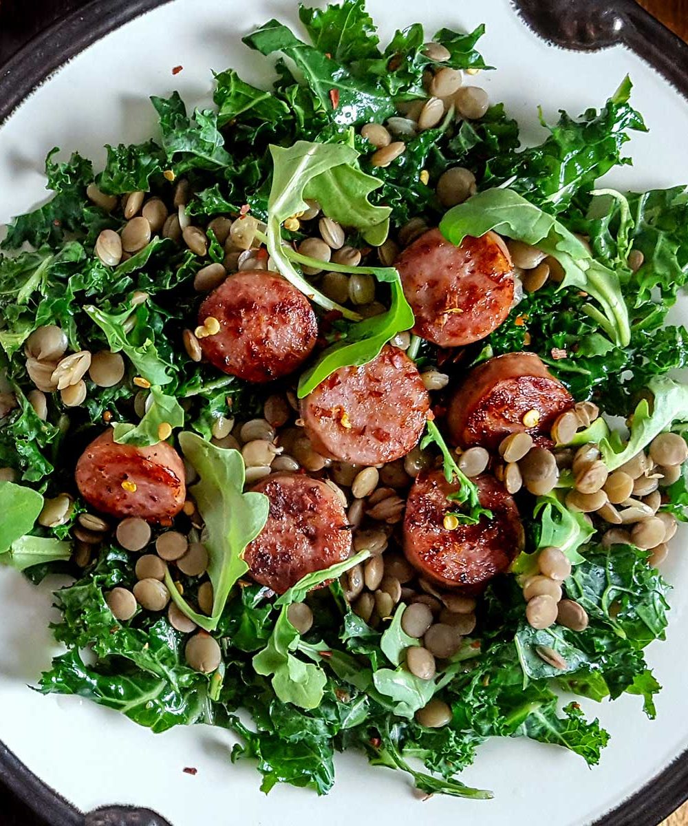 A salad with sausage, kale, and lentils