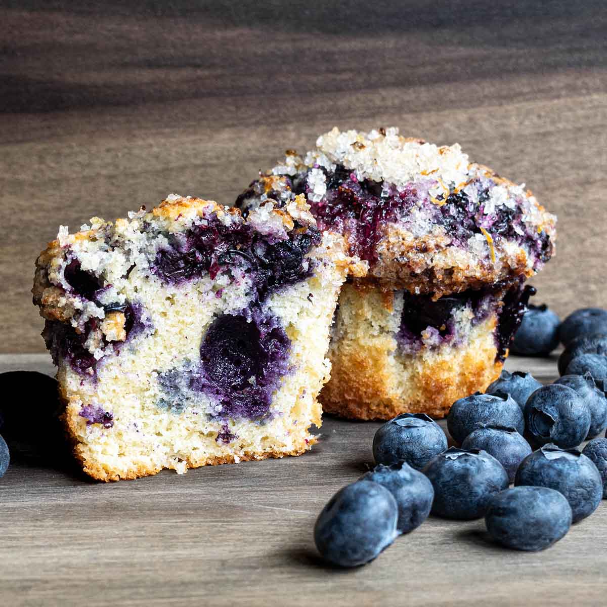 Blueberry muffins cut in half to show the fluffy, cakey texture