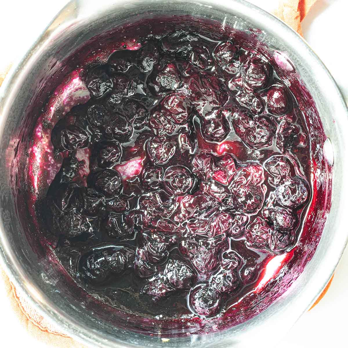 Blueberry compote in a pan that can be left whole or pureed