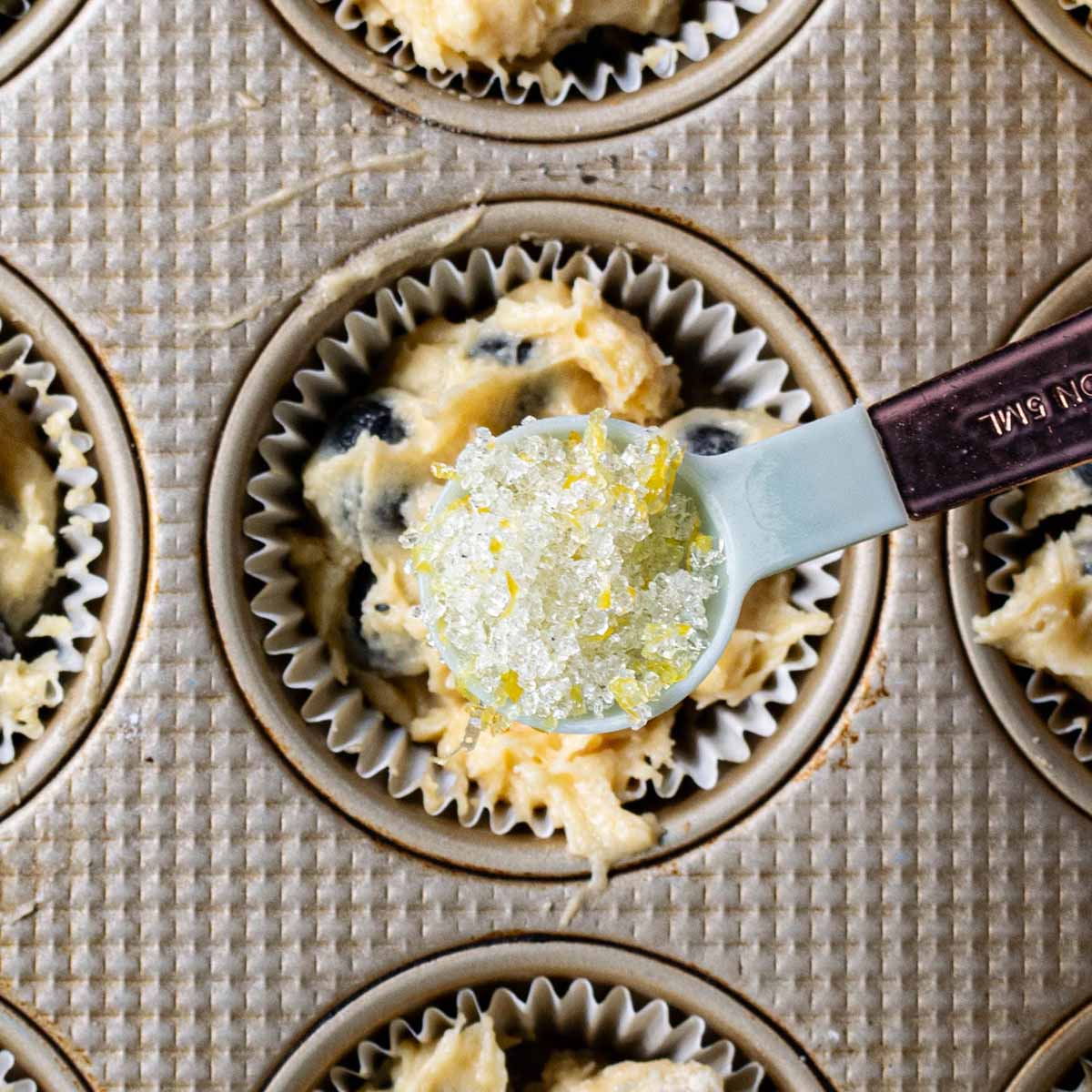 A teaspoon of lemon sugar over a blueberry muffin