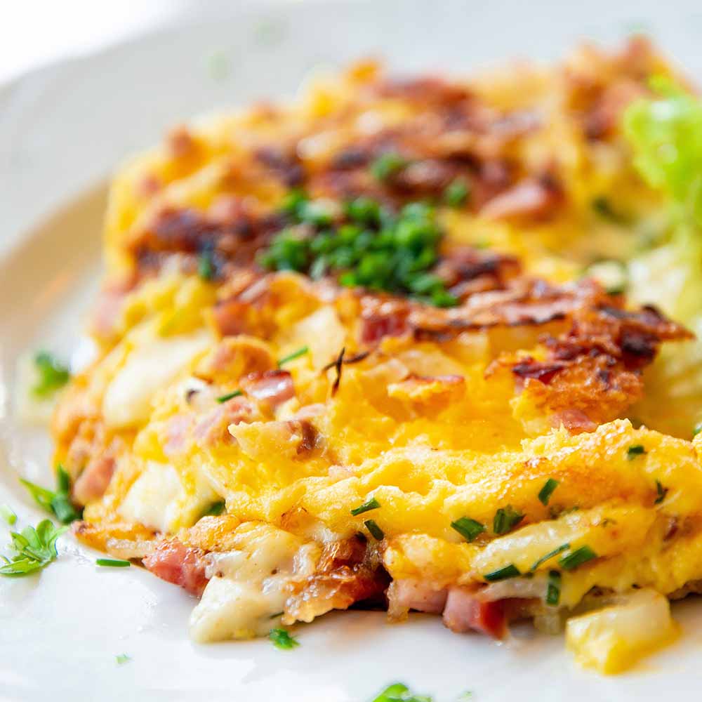 An omelet topped with chives (to be replaced with chopped nasturtium stems)