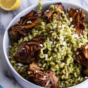 A bowl of pasta with pesto and fried artichokes