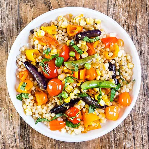 Fregola pasta with fresh vegetables.
