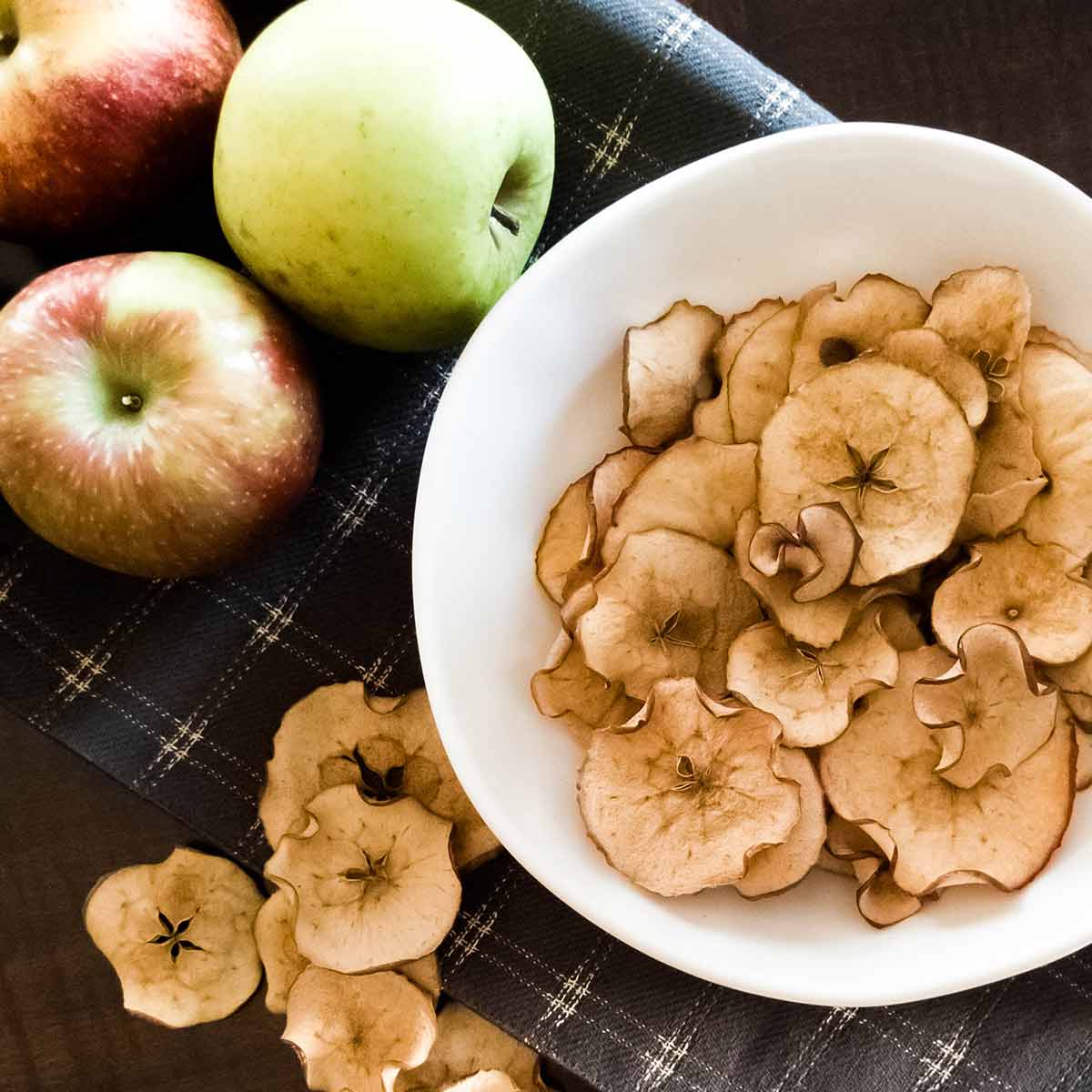 Apple chips and apples on a table