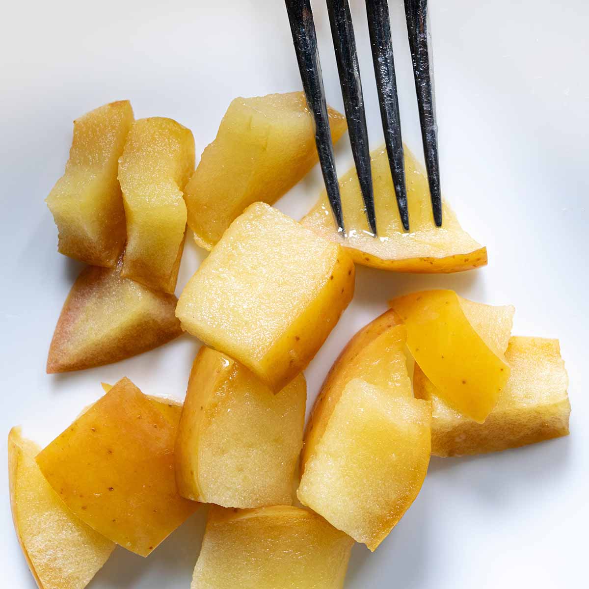 Fuji apples baked for a pie. The slices are tender but hold their shape when pressed with a fork.