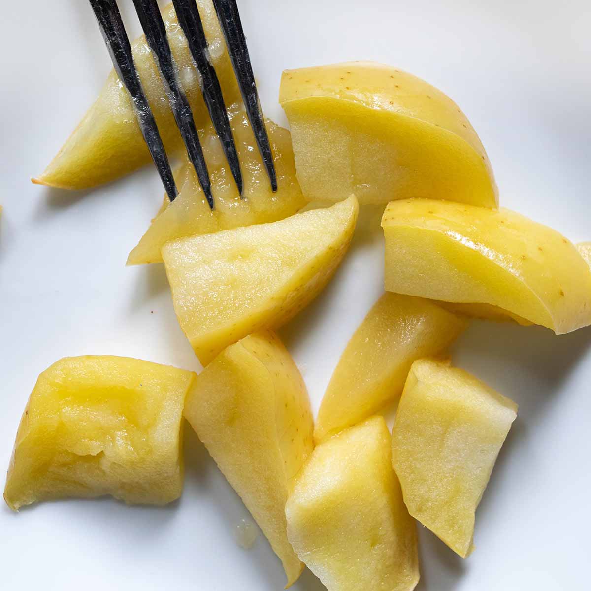 Golden delicious apples baked for an apple pie test. Slices are tender but hold their shape when pressed with a fork.