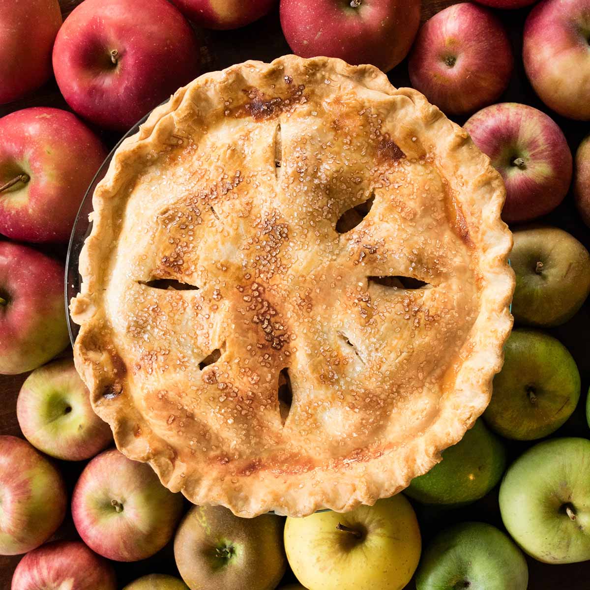 apple pie on a pile of red and green apples