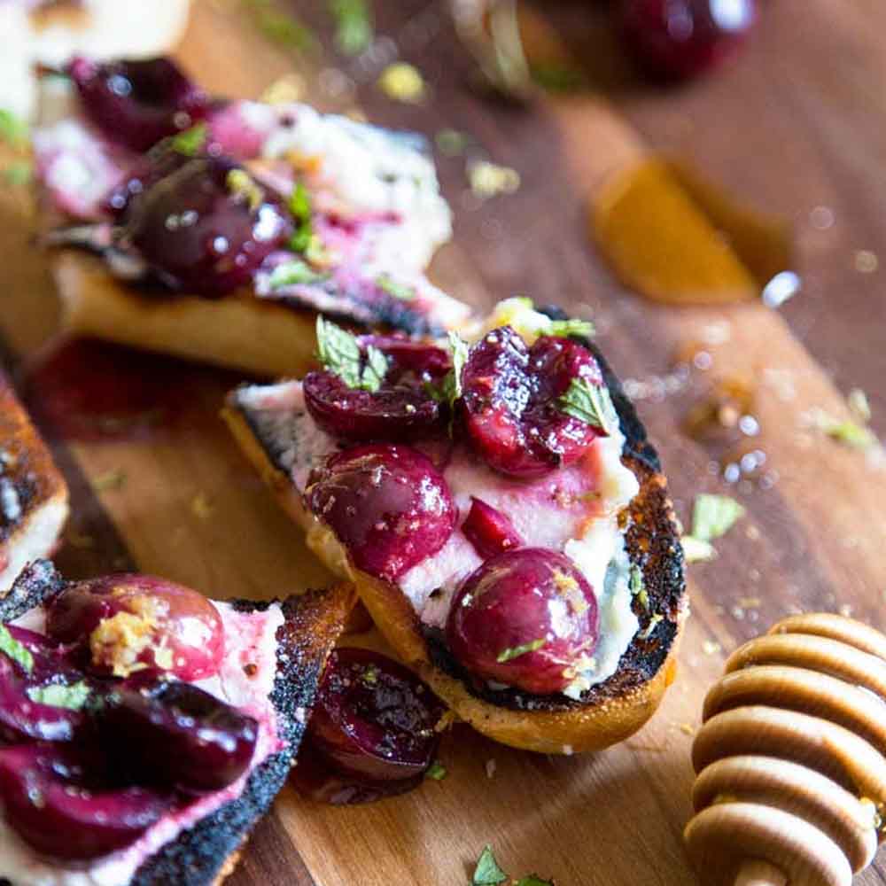 Bruschetta slices with ricotta and fresh cherries, recipe from Kevin is Cooking.