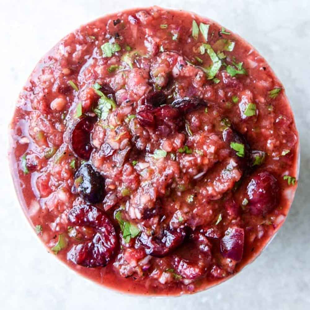 Grilled cherry salsa on a white counter top, recipe from How Sweet Eats