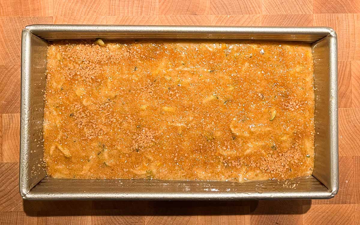 Zucchini bread batter in a 9x5 loaf pan with sugar sprinkled on top