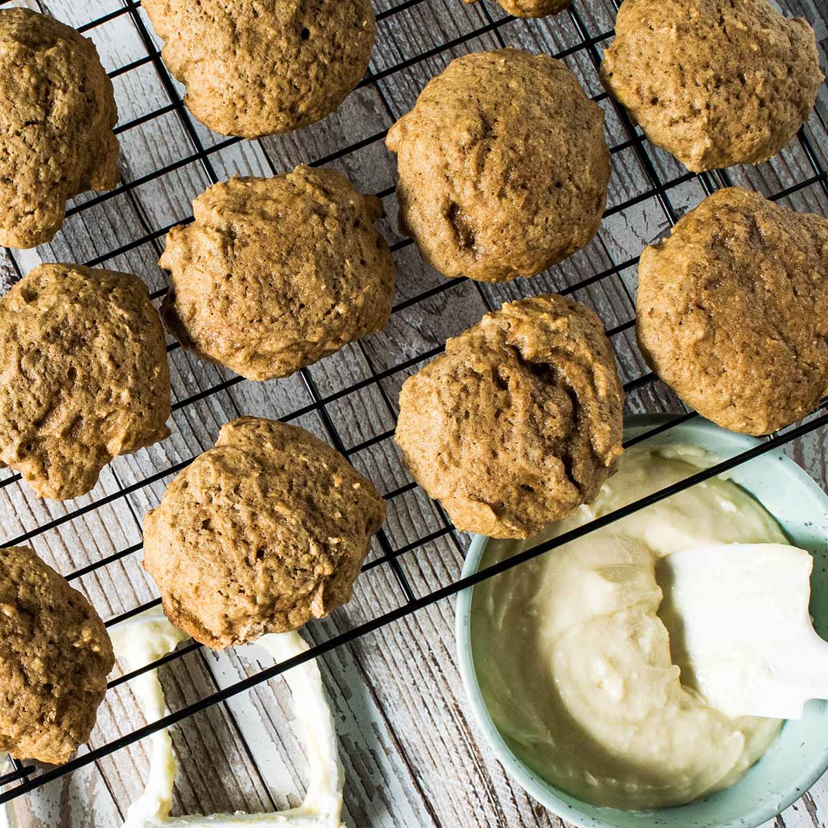 Pawpaw cookies on a cooling rack next to a bowl of pawpaw frosting