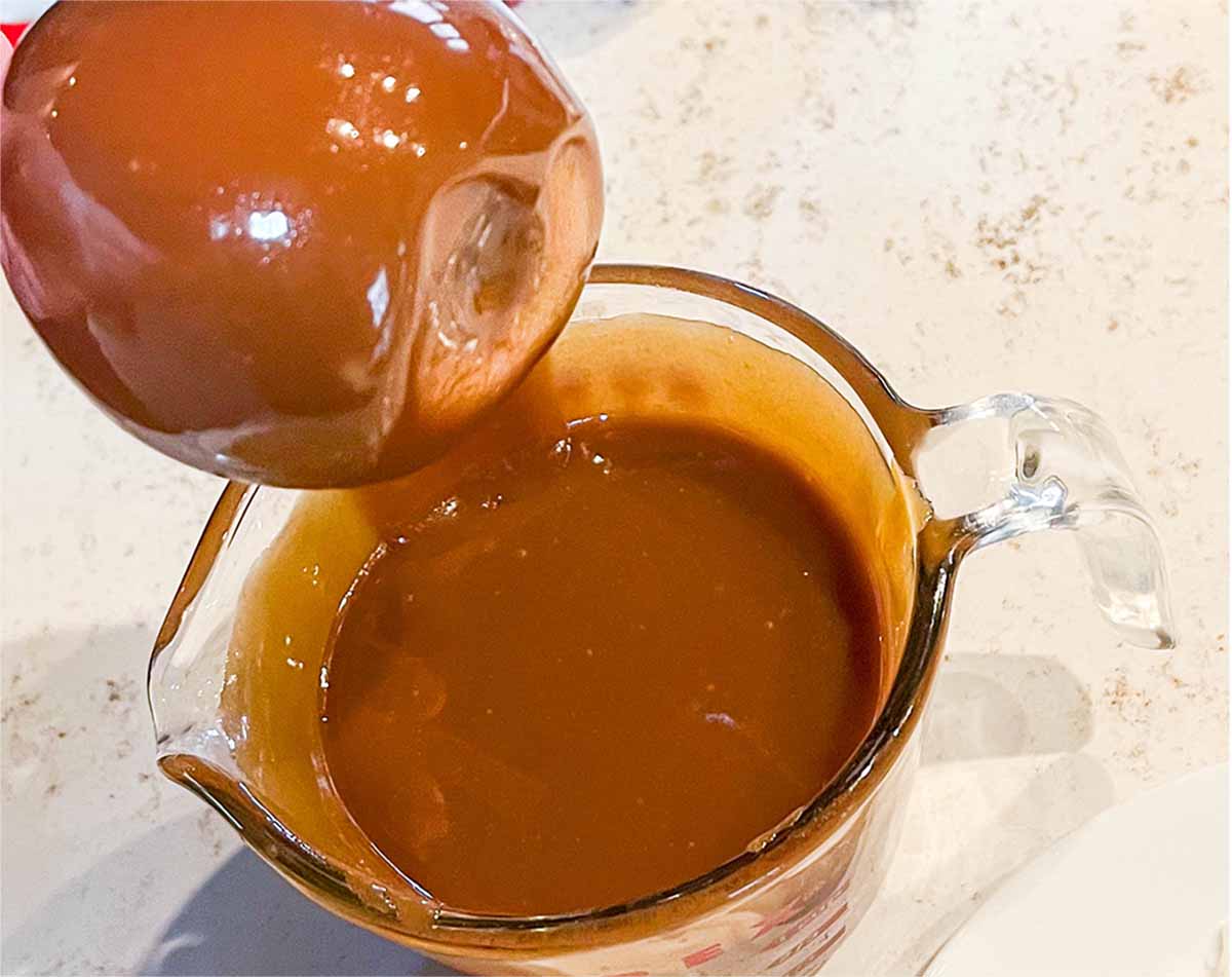 Dipping an apple into homemade caramel.