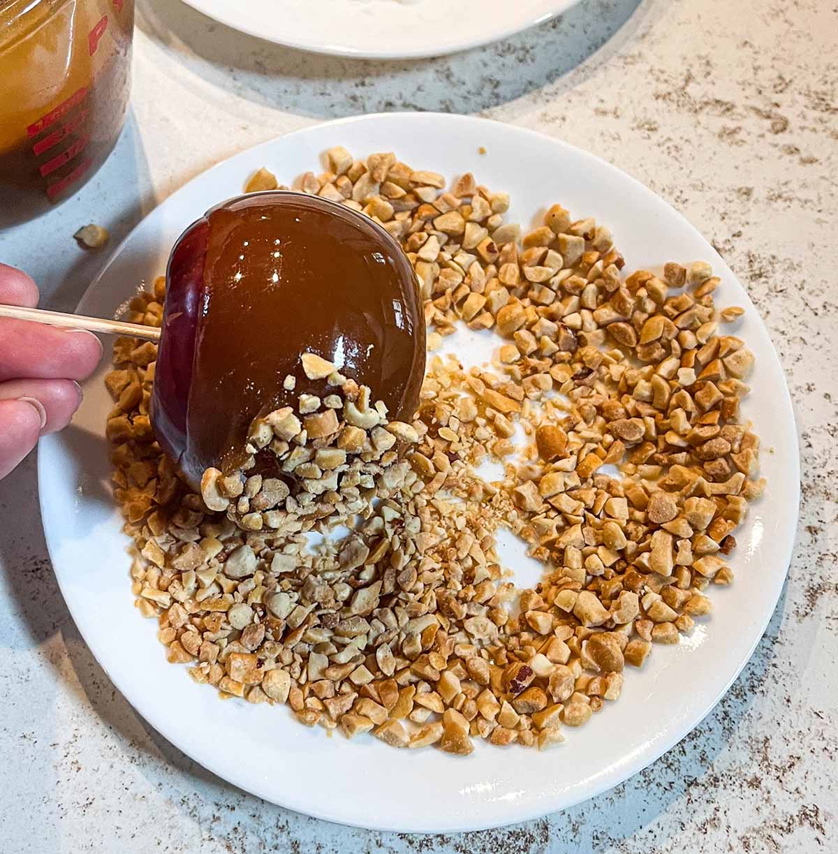 Dip the caramel apple in toppings, like chopped nuts, while the caramel is still tacky.