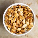 Roasted squash and pumpkin seeds in a white bowl