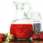 Strawberry salad dressing with poppy seeds on a table