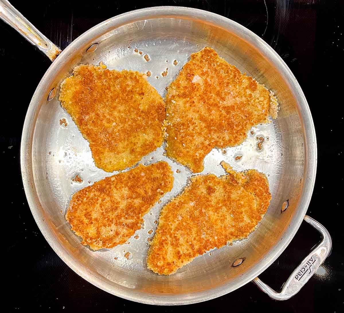 Breaded pork chop schnitzel in a pan