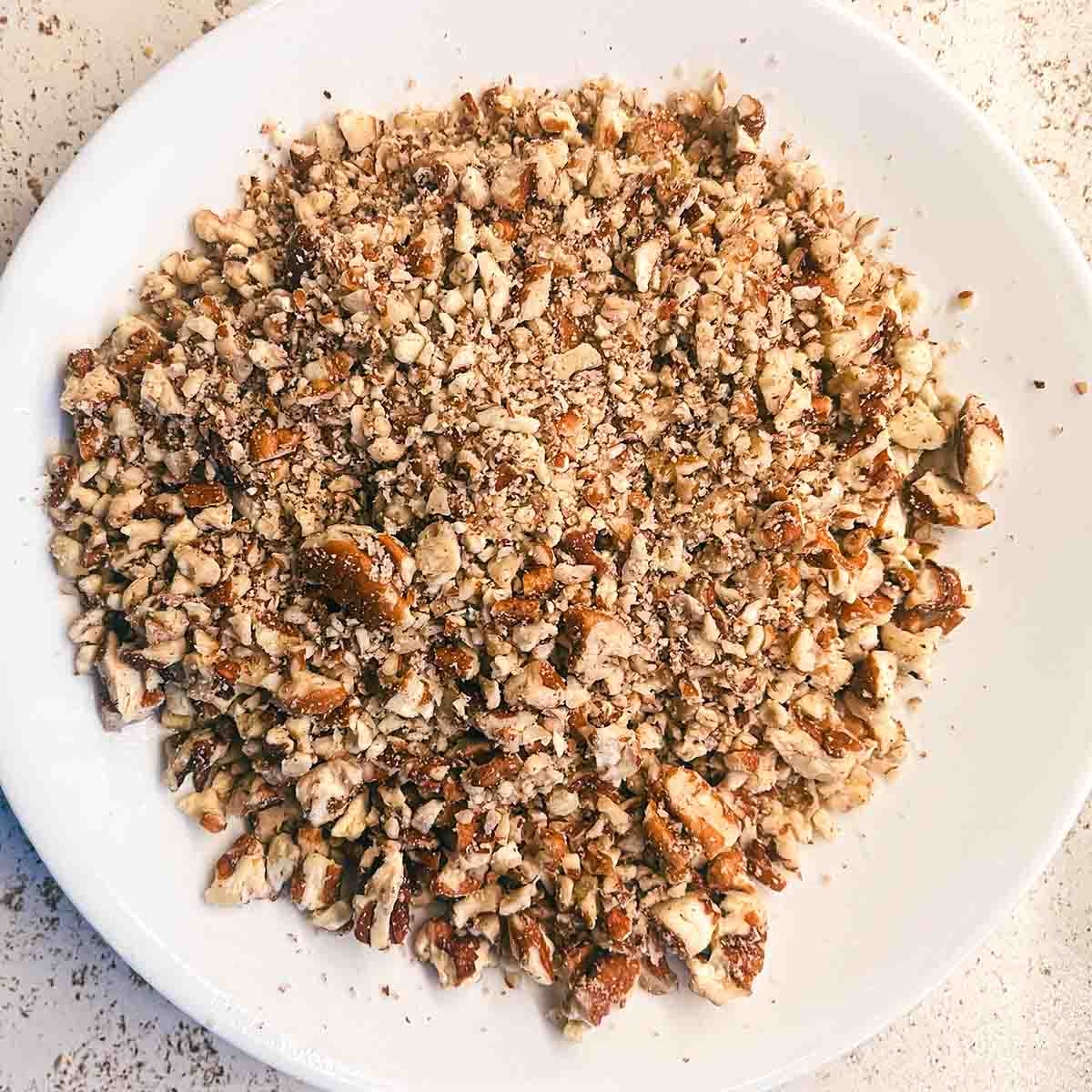 Chopped pecans on a plate, finely chopped for the cookies.
