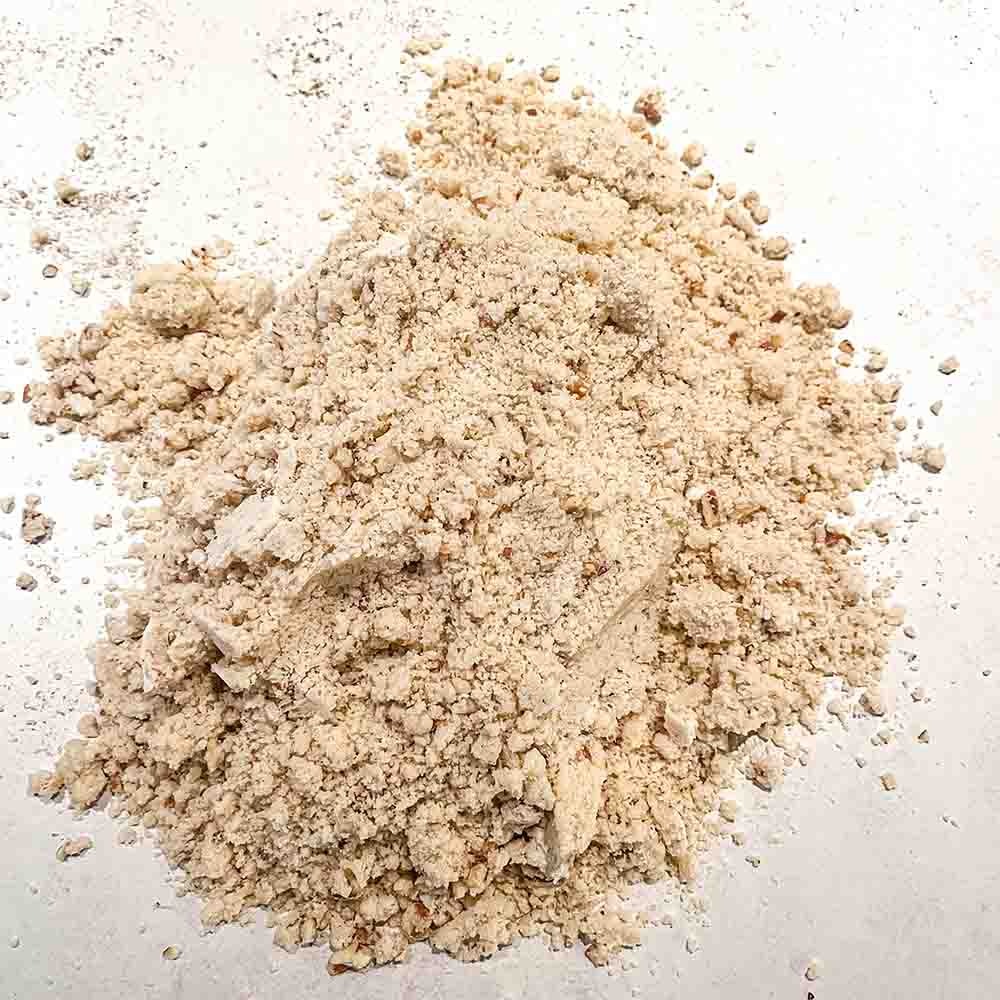 Raw maple pecan cookie dough that is dry and crumbly, on a counter, ready to be mixed