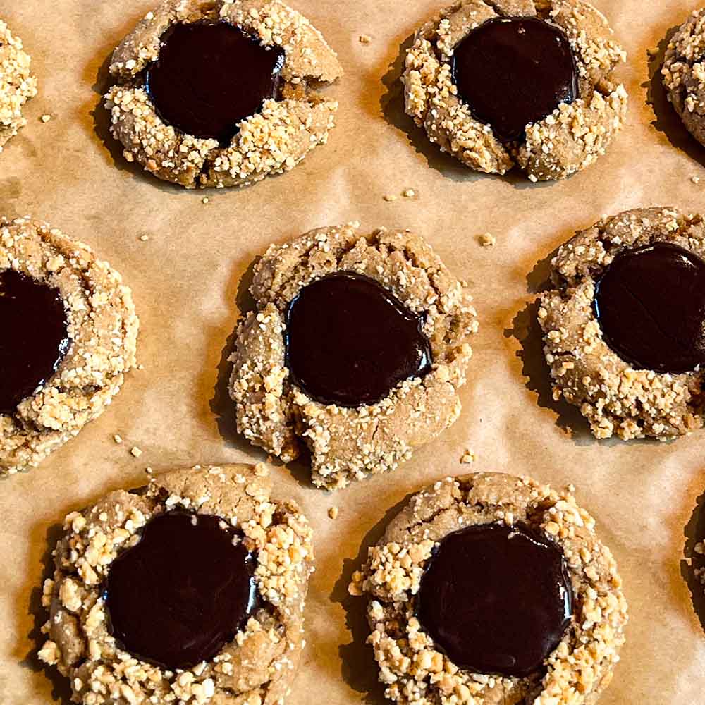 Soft & chewy peanut butter blossoms after baking and filled with an alternative to Hershey kisses, using a ganache instead.