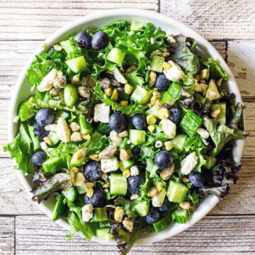 A plate of blueberry cucumber salad with feta cheese and pistachios