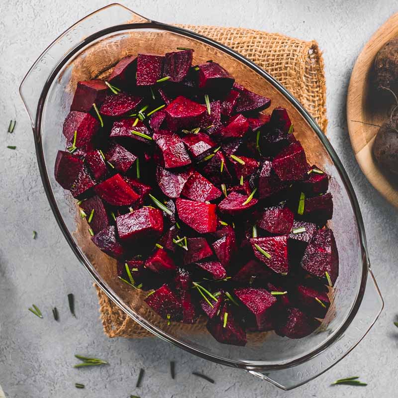 A glass dish of beets with rosemary, cinnamon, and balsamic vinegar. From Beet of the Wild.