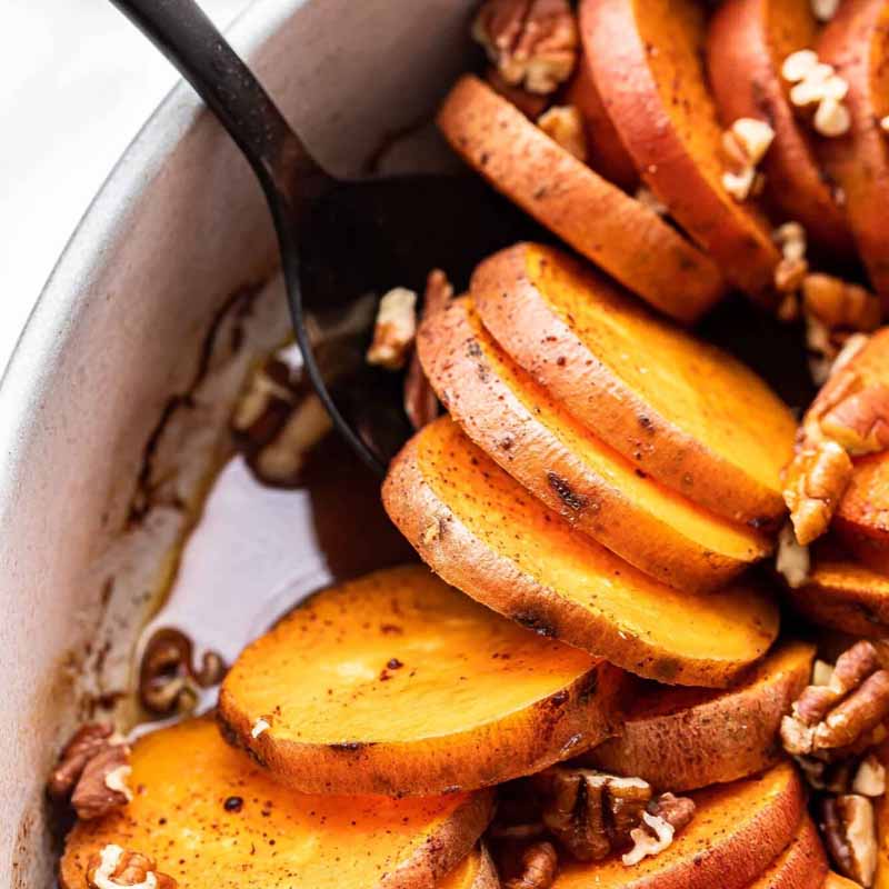 Bourbon sweet potatoes in a baking dish, a Friendsgiving recipe alternative to the traditional casserole.