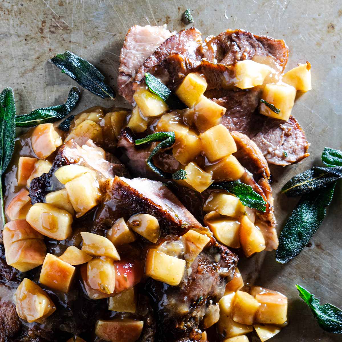Apple cider braised pork shoulder, covered with a cider gravy, apples, and fried sage.