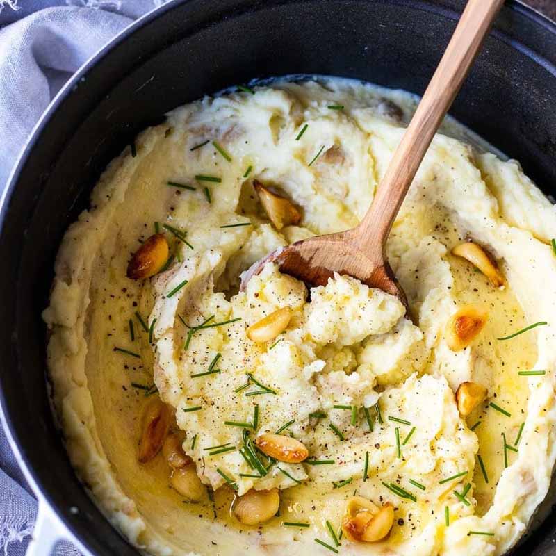 Mashed potatoes with whole garlic cloves and chives. Recipe by Feasting At Home.