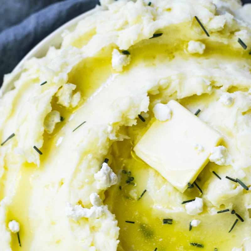 Goat cheese mashed potatoes made with white wine topped with butter. Recipe by Food Above Gold.