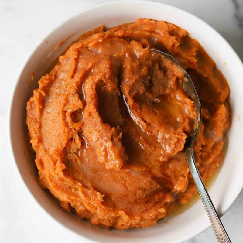 Maple cinnamon mashed sweet potatoes in a bowl with a spoon. A Thanksgiving recipe by The Healthy Epicurian