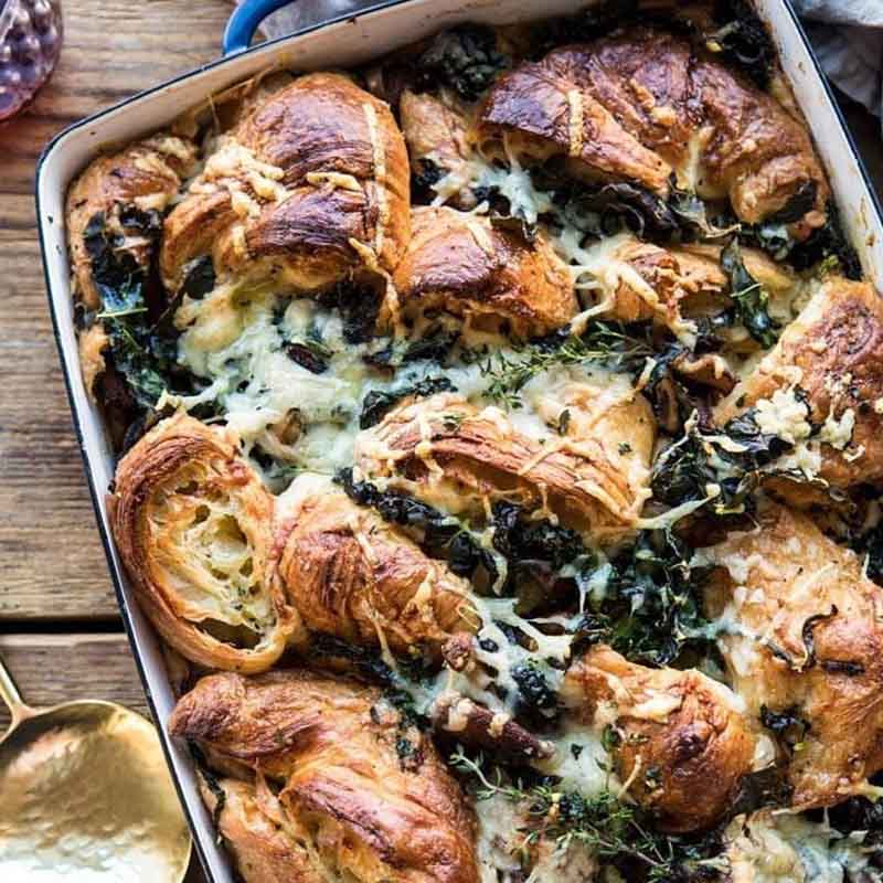 A dish of stuffing made with croissants, herbs, and mushrooms. Recipe by Half Baked Harvest.