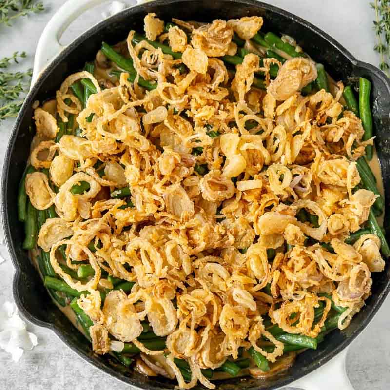 A skillet with a Cajun flavored green bean casserole, as a Friendsgiving food idea related to the classic side dish.