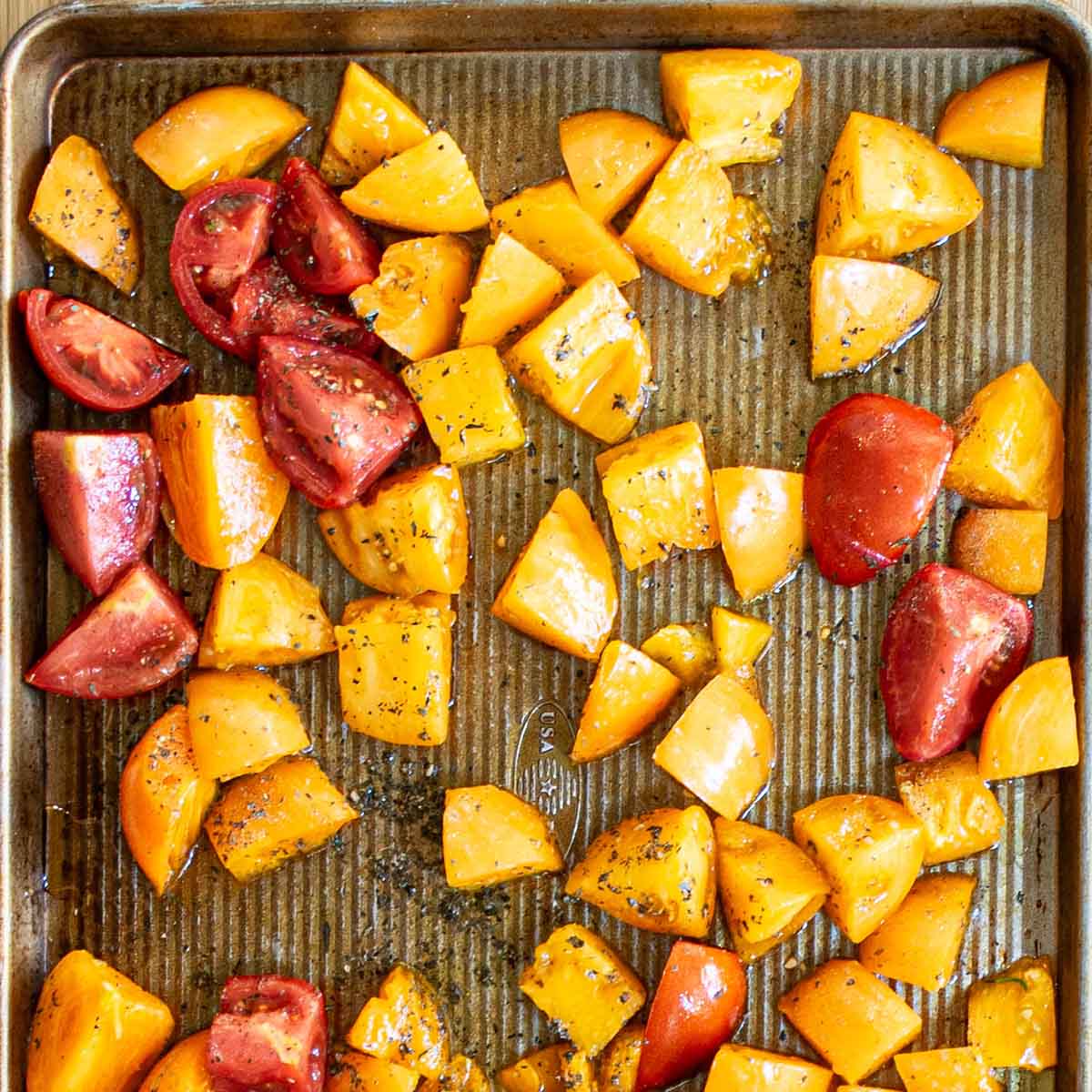 Fresh yellow and red tomatoes from the garden, cut into quarters for roasting.