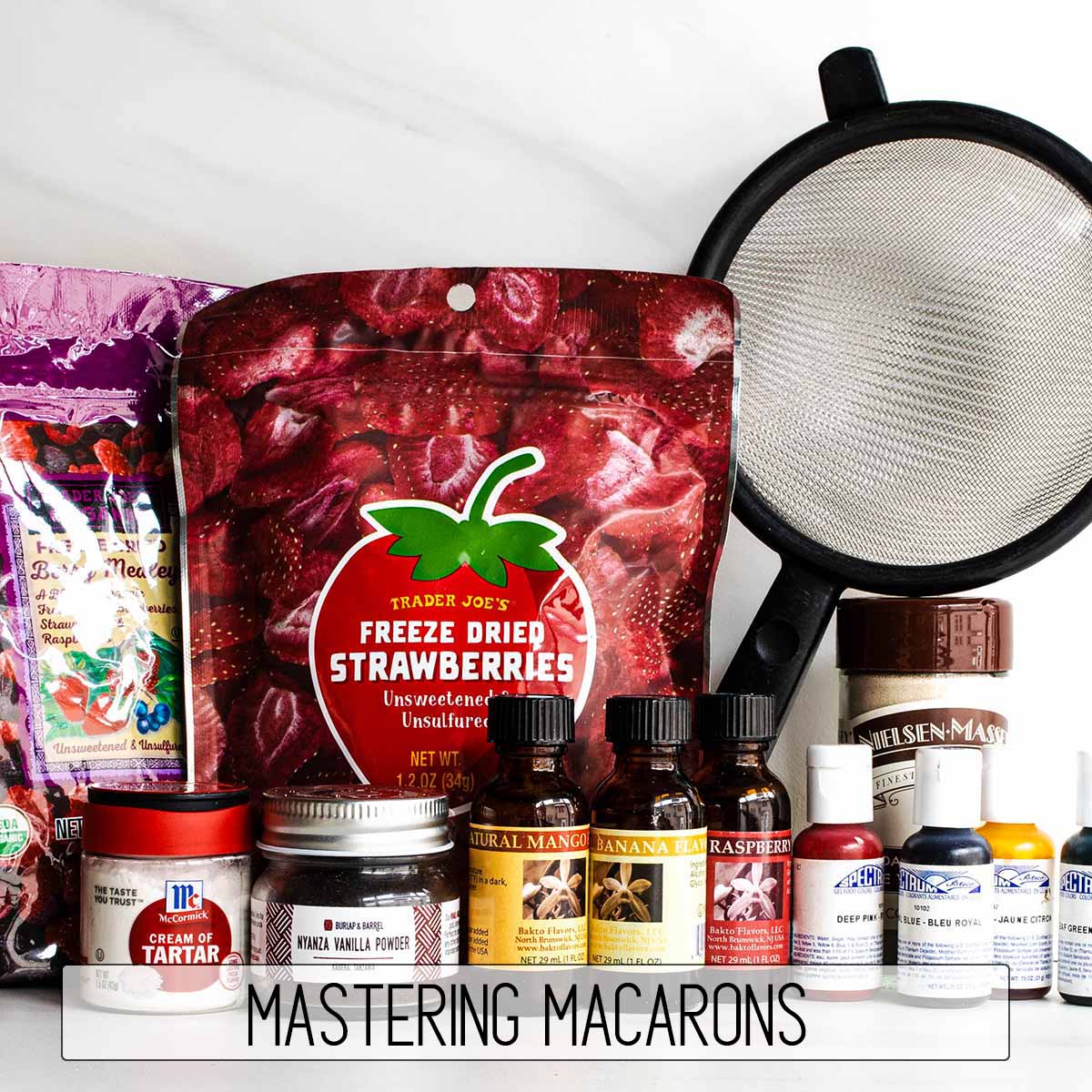 Unique gift idea for a baker who has everything: a macaron kit that includes freeze dried fruit, cream of tartar, vanilla powder, fruit extract flavorings, gel food dye, and a sifter for almond flour.