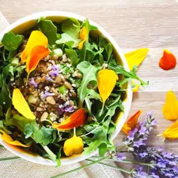 Salad with edible flowers, arugula, lentils, and couscous.