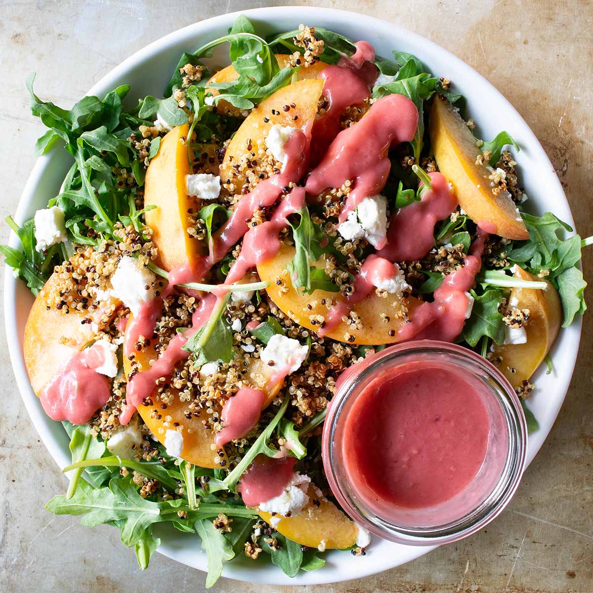 A peach and arugula salad topped with crispy quinoa.