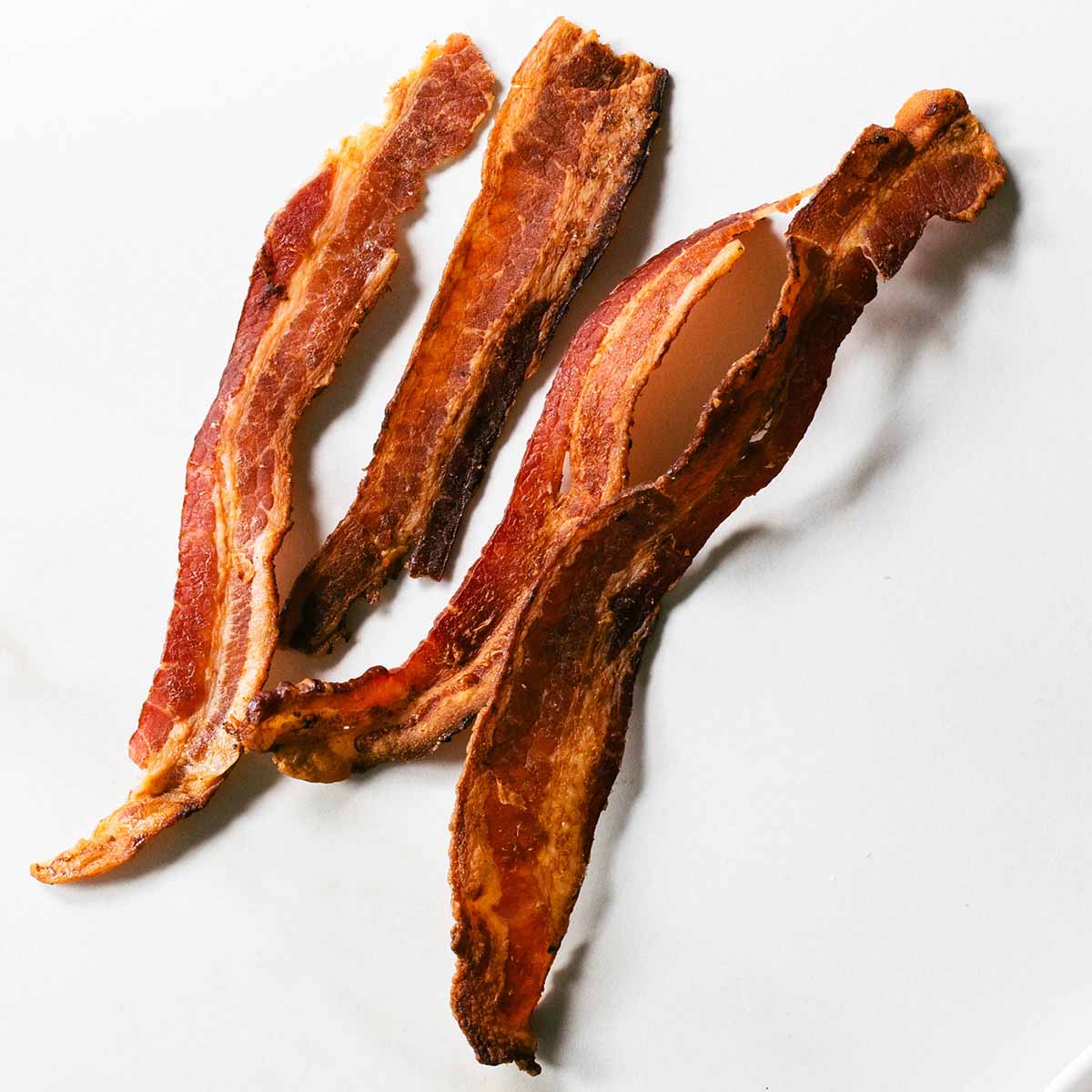 Thin cut bacon cooked until it's crispy so it breaks cleanly when biting into the tall club sandwich.