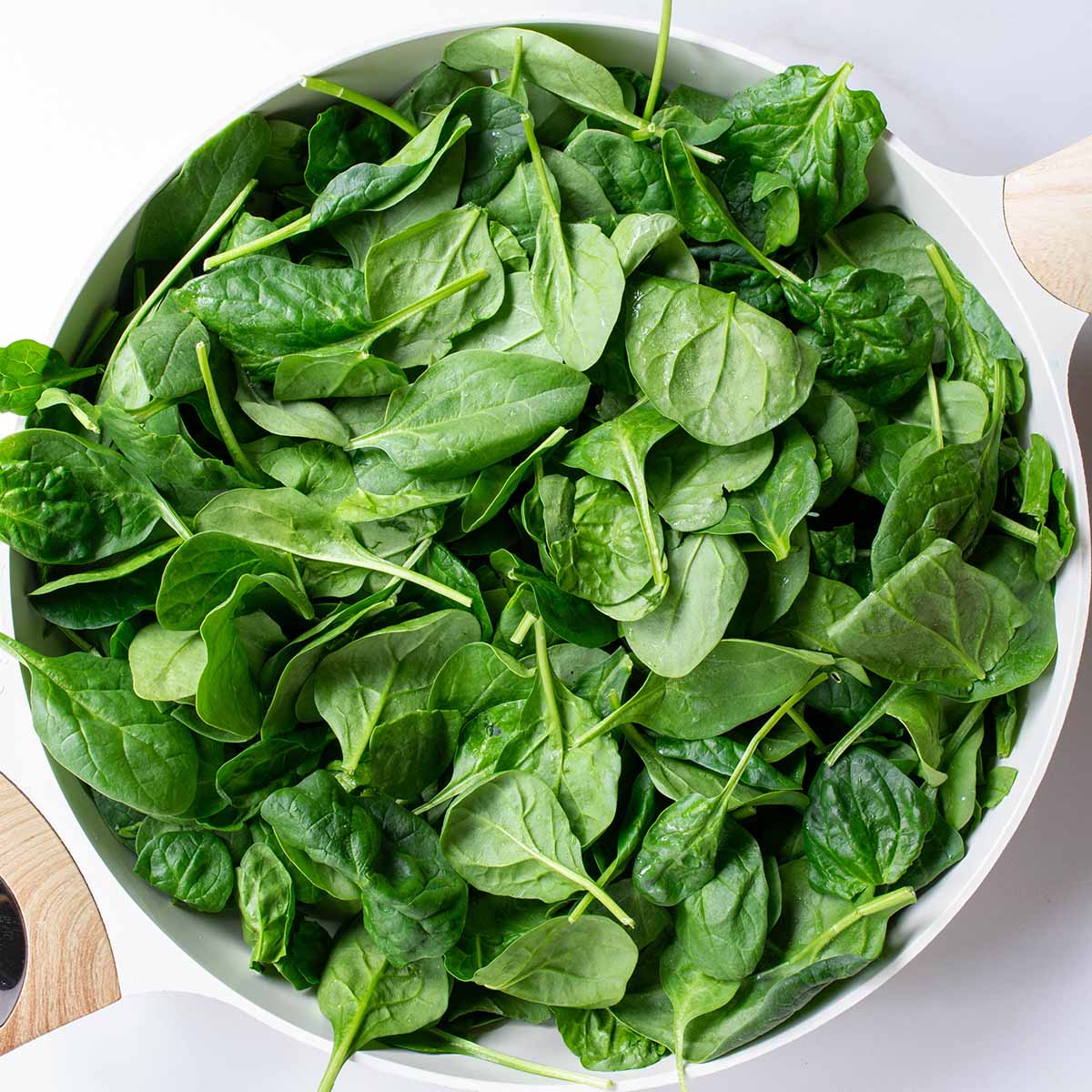 16 ounces of raw baby spinach in a pan.