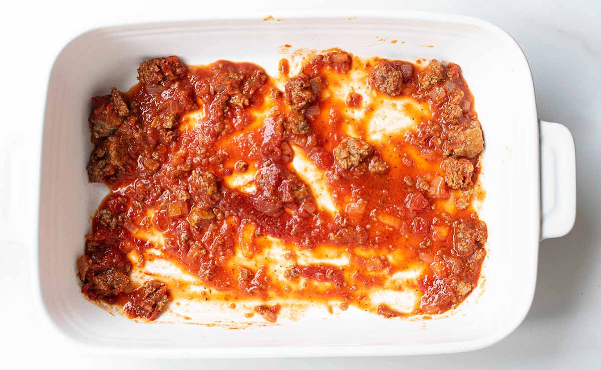 1 cup of meat sauce on the bottom of a lasagna pan.