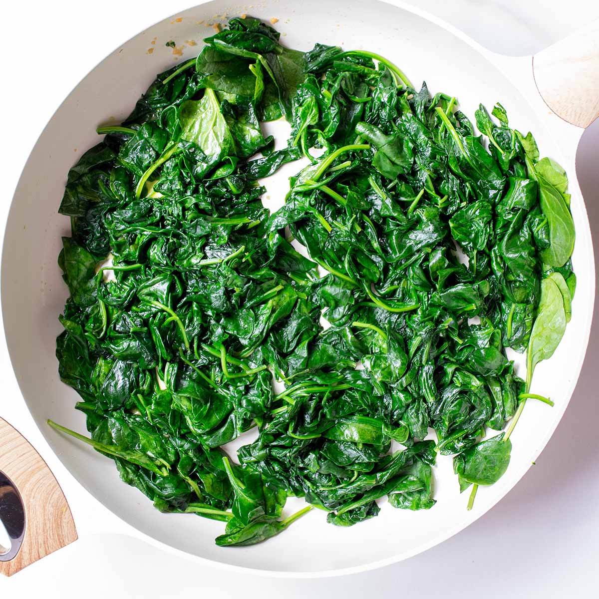 Fully cooked spinach in a pan for lasagna.