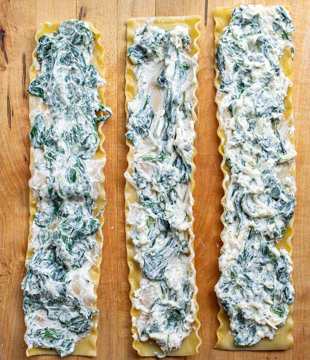 Lay lasagna noodles flat and spread ricotta mixture evenly over the surface, then roll them up.